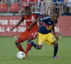 Toronto FC Ashtone Morgan, left, battles for the ball against New York Red Bulls Dane Richards, right, during second half MLS soccer action in Toronto on Saturday June 30, 2012. THE CANADIAN PRESS/Aaron Vincent Elkaim