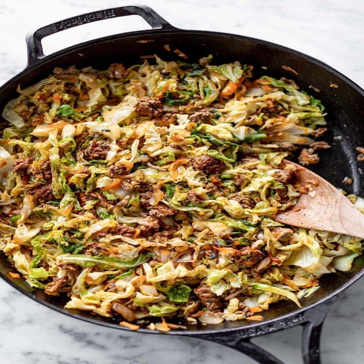 A skillet with cabbage, ground beef, and veggies.