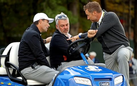 Team Europe vice-captain Padraig Harrington, Team Europe captain Darren Clarke and Team Europe vice-captain Ian Poulter talk on the sixth green during a practice round - Credit: Rob Schumacher/USA TODAY Sports