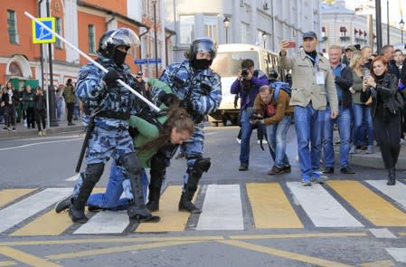 Law enforcement officers detain a man after a rally to demand authorities allow opposition candidates to run in a local election in Moscow