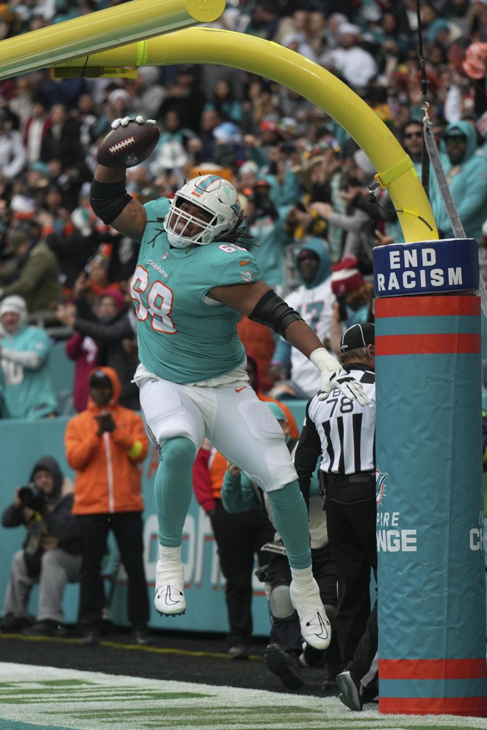 Miami Dolphins offensive tackle Robert Hunt (68) celebrates after a touchdown by teammate Miami Dolphins running back Jeff Wilson Jr. (23), during the first half of an NFL football game against the Green Bay Packers, Sunday, Dec. 25, 2022, in Miami Gardens, Fla. (AP Photo/Jim Rassol)