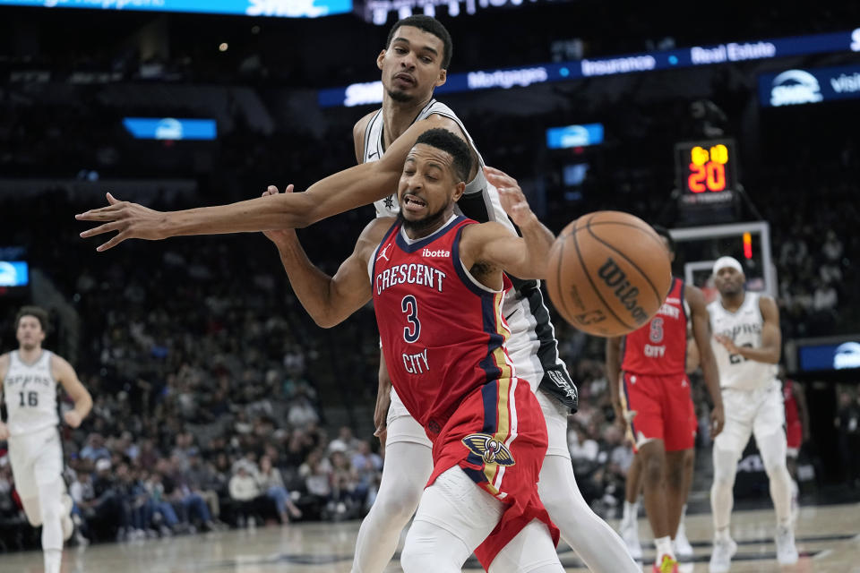 San Antonio Spurs center Victor Wembanyama (1) knocks the ball away from New Orleans Pelicans guard CJ McCollum (3) during the second half of an NBA basketball game in San Antonio, Sunday, Dec. 17, 2023. (AP Photo/Eric Gay)