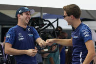 Williams drivers Nicholas Latifi, of Canada, left, and George Russell, of Britain, right, react as they shoot free throws during a contest at the Formula One U.S. Grand Prix auto race at the Circuit of the Americas, Thursday, Oct. 21, 2021, in Austin, Texas. F1 Teams took part in a free throw challenge as to help the NBA celebrate their 75th Anniversary. (AP Photo/Eric Gay)