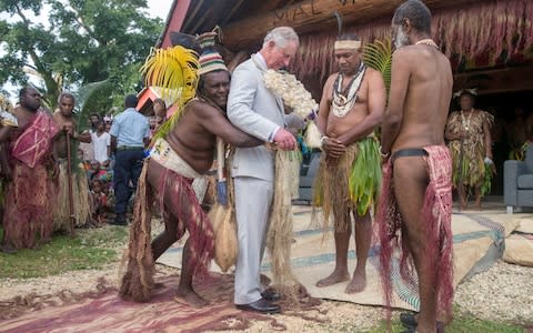 Prince Charles tries on his grass skirt while visiting the South Pacific island nation of Vanuatu  - Credit: Steve Parsons/PA Wire