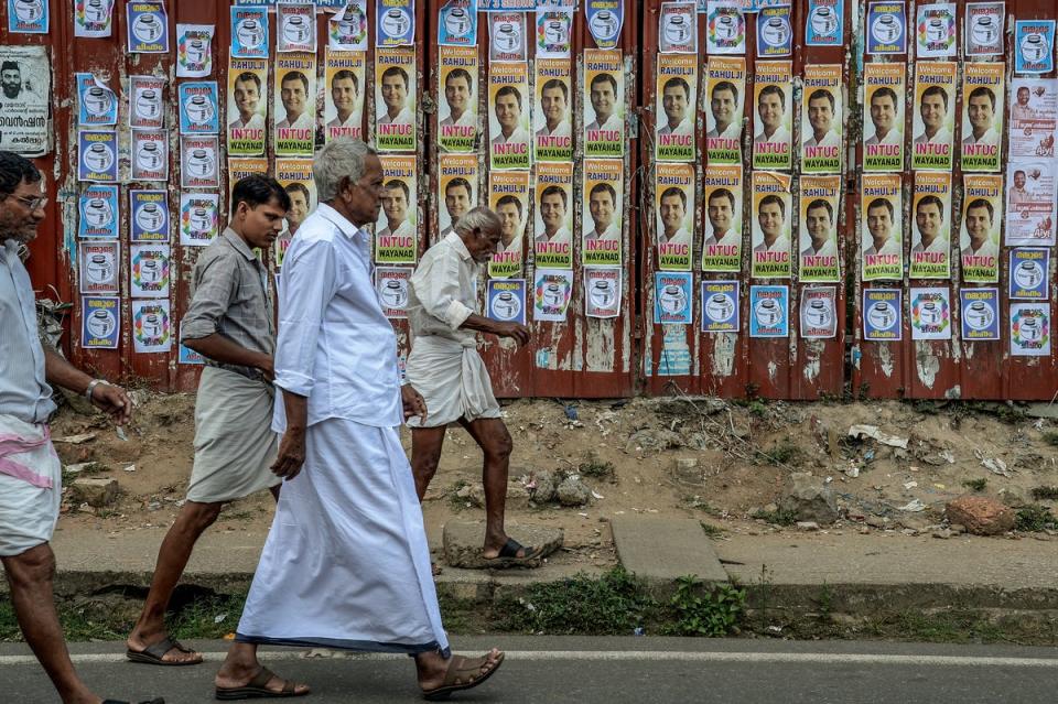 File: Congress party supporters walk in front of posters of Rahul Gandhi after he files nominations from Wayanad district on April 4, 2019 (Getty Images)