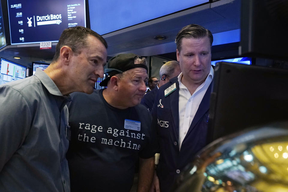 President and CEO of Dutch Bros Coffee Joth Ricci, left, and Travis Boersma, center, co-Founder and President, meet with specialist Gregg Maloney on the floor of the New York Stock Exchange, before their IPO, Wednesday, Sept. 15, 2021. (AP Photo/Richard Drew)