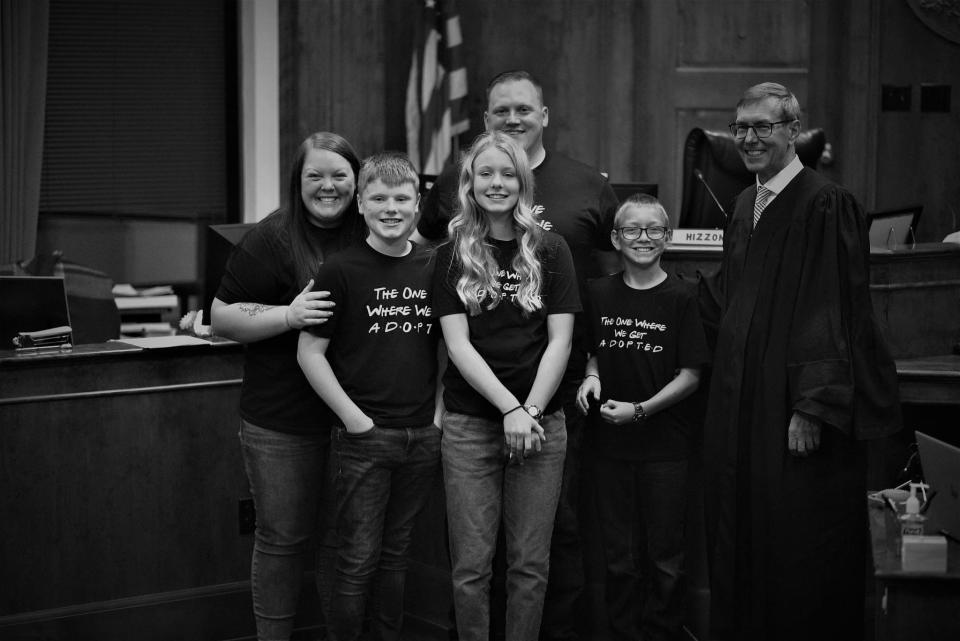 From left to right: Jessica Passamoni, 32, Coltyn Feld, 13, Charlotte Passamoni, 13, Shane Passamoni, 34, Alec Passamoni, 12, and Brown County Circuit Court Judge John Zakowski. The Passamonis adopted Charlotte and Alec in September 2022 after fostering them more than two years.