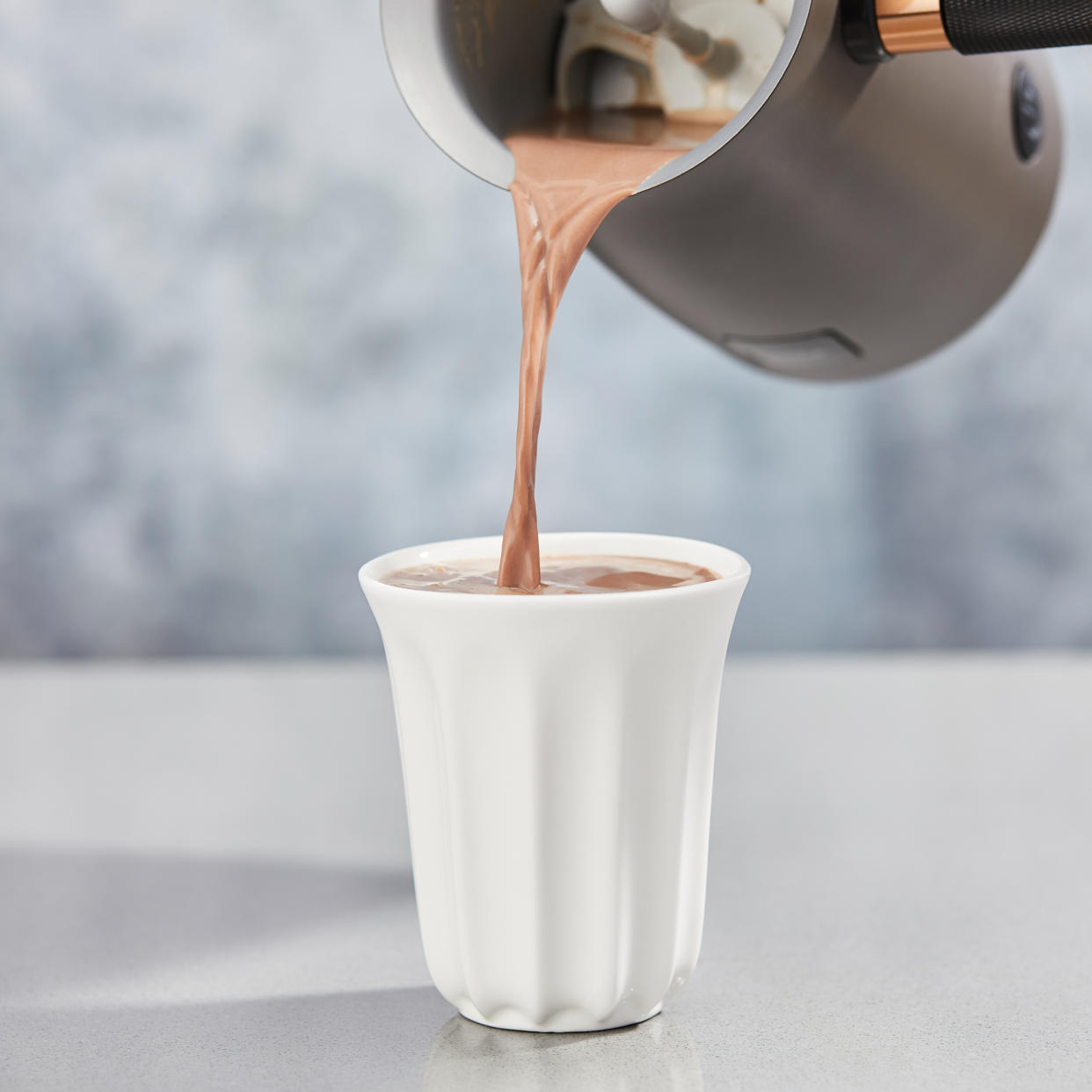  Hotel Chocolat Velvetiser pouring hot chocolate into white mug. 