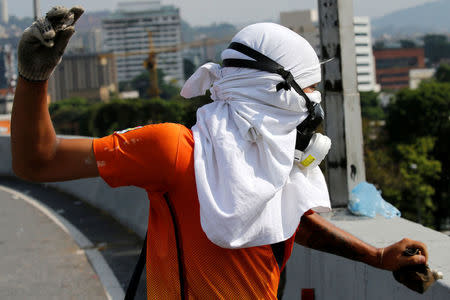 A demonstrator throws stones at riot police during a rally against Venezuela's President Nicolas Maduro's government in Caracas, Venezuela April 24, 2017. REUTERS/Carlos Garcia Rawlins