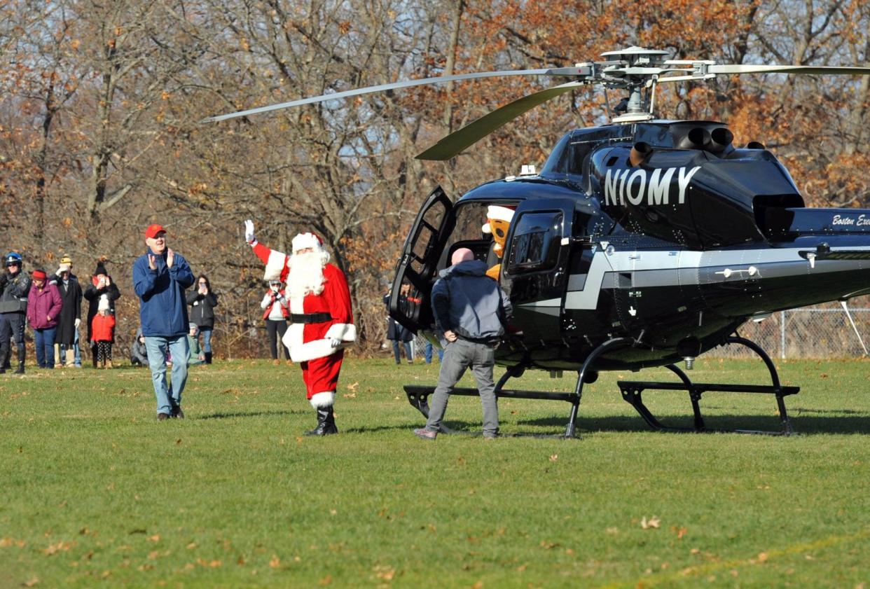Santa Claus waves to the crowd after arriving by helicopter at Pageant Field in Quincy on Saturday, Nov. 27, 2021.