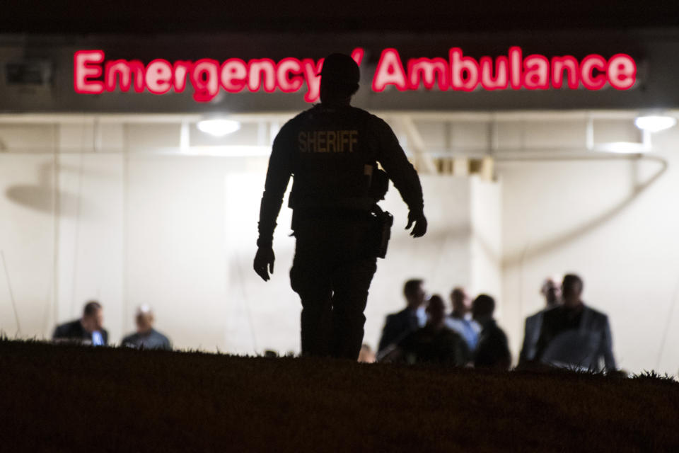 A Riverside Sheriff's deputy walks toward the emergency room entrance to the Riverside University Health System Medical Center in Moreno Valley after a California Highway Patrol officer was killed in a shootout in Riverside on Monday, Aug 12, 2019. (Watchara Phomicinda/The Orange County Register via AP)