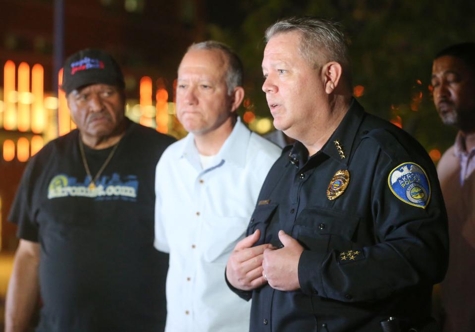 Akron Police Chief Steve Mylett talks as Mayor Dan Horrigan, center, and Deputy Mayor Marco Sommerville listen Friday night outside Akron Children's Hospital.