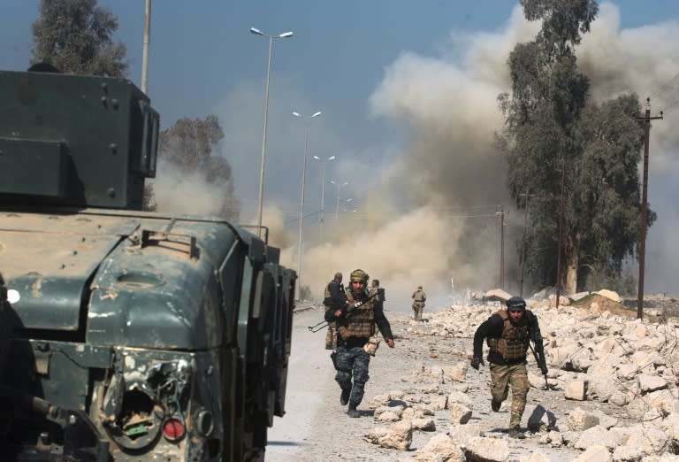 Smoke billows in the background as Iraqi forces advance on Mosul airport during an offensive to retake the western side of the city from jihadists of the Islamic State group on February 23, 2017