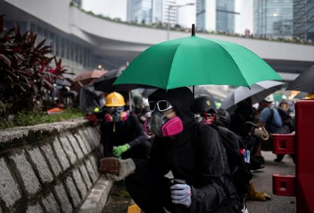 Demonstrator prepares to throw a brick at police during a protest in Hong Kong