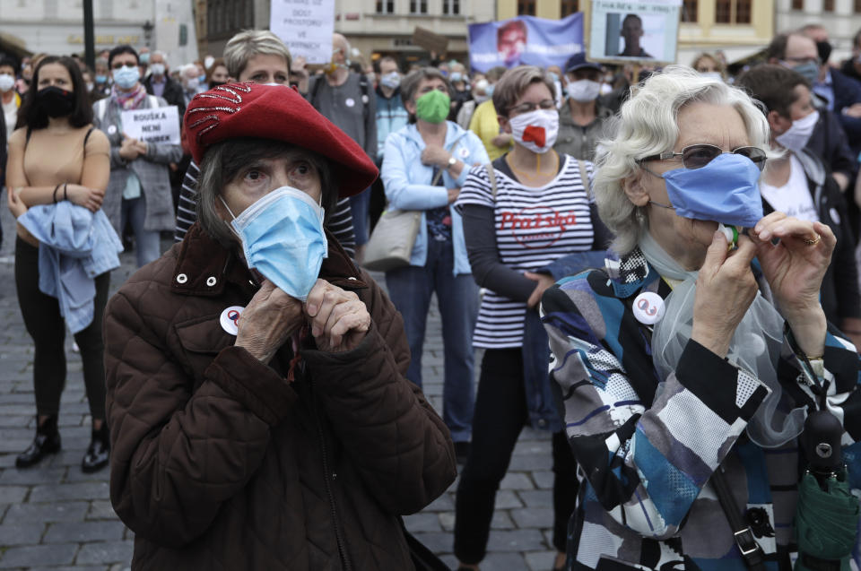 Elderly women wearing face masks to protect against coronavirus, blow whistles, during a protest at the Old Town Square in Prague, Czech Republic, Tuesday, June 9, 2020. Hundreds of people protested in the Czech capital to draw attention to the government's insufficient and chaotic response to the coronavirus outbreak and other financial issues. (AP Photo/Petr David Josek)