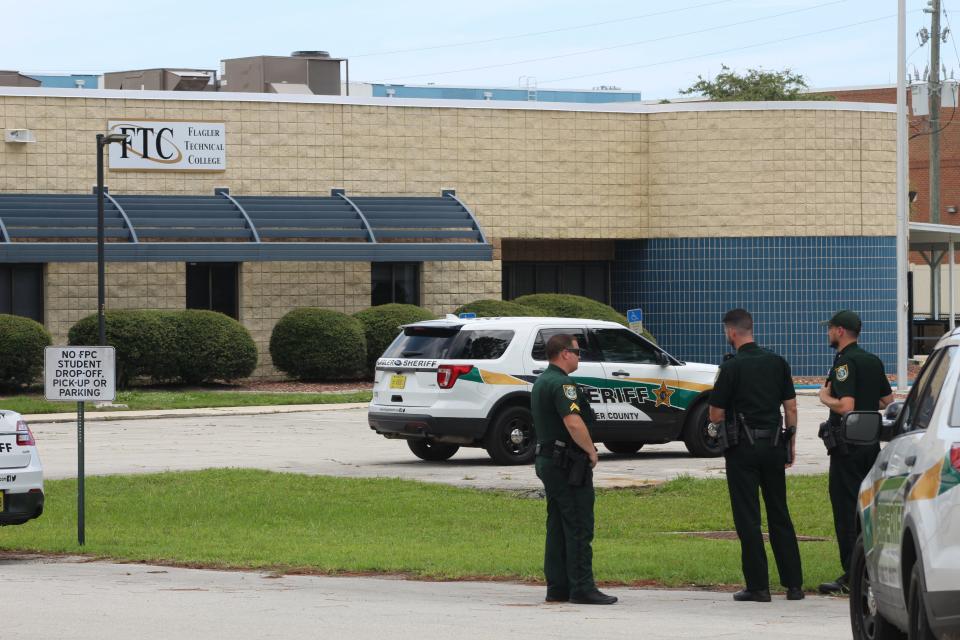 Flagler County Sheriffs Office deputies stand outside the Flagler Technical College on Thursday after a bomb threat was called in about noon. The building was evacuated and about a half-dozen employees stood by the sidewalk near State Road 100.