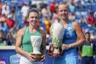 La holandesa Kiki Bertens, derecha, sostiene la copa Rookwood tras vencer a la número uno del mundo Simona Halep en la final femenil del torneo de Cincinnati, el domingo 19 de agosto de 2018, en Mason, Ohio. (AP Foto/John Minchillo)