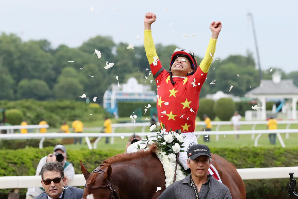 Mike Smith celebrates atop Justify after winning the Belmont Stakes and the Triple Crown. (Getty)