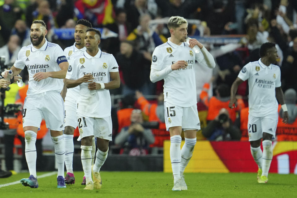 Karim Benzema (izquierda) celebra tras anotar el quinto gol del Real Madrid ante Liverpool en los octavos de final de la Liga de Campeones, el martes 21 de febrero de 2023, en el estadio Anfield. (AP Foto/Jon Super)