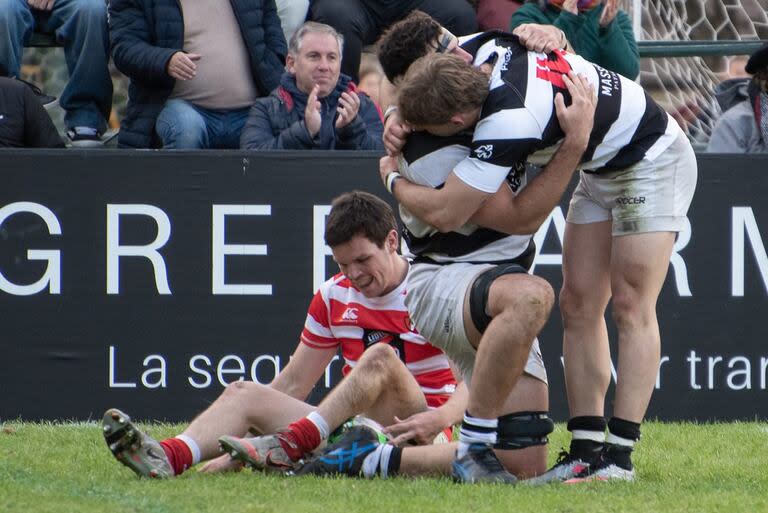 Leo Mazzini y Santiago David festejan uno de los tries del CASI; lo sufre Cruz González Bibolini, de Alumni