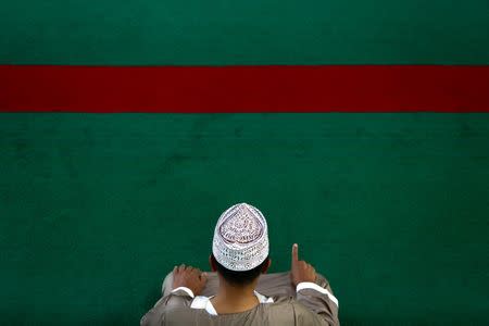 A Muslim prays before an Eid al-Fitr mass prayer to mark the end of the holy fasting month of Ramadan at a mosque in Bangkok, Thailand, June 25, 2017. REUTERS/Athit Perawongmetha