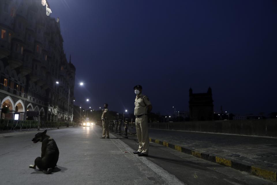 Security personnel guard near Gateway of India monument in Mumbai, India, Wednesday April 14, 2021. The teeming metropolis of Mumbai and other parts of Maharashtra, the Indian state worst hit by the pandemic, face stricter restrictions for 15 days starting Wednesday in an effort to stem the surge of coronavirus infections. (AP Photo/Rajanish Kakade)