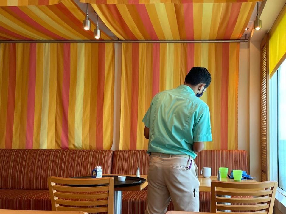 A crew member cleans up a table moments after guests are done eating.