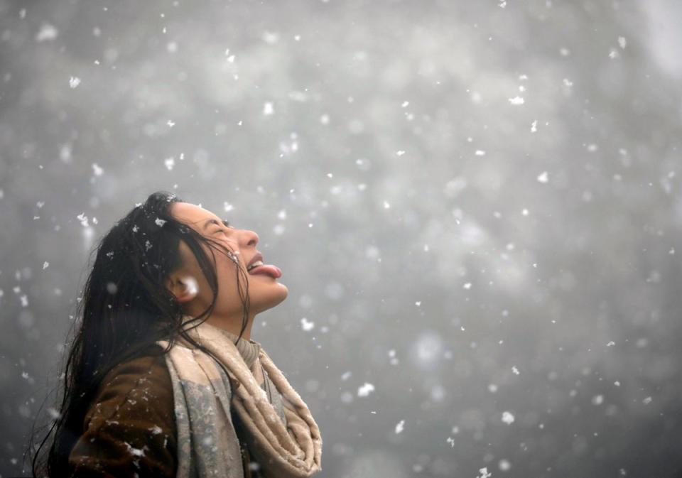 Nepal: A woman tries to catch snowflakes with her tongue during a snowfall on Chandragiri Hills in Kathmandu (Reuters)