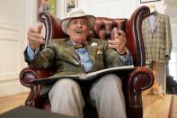 Domenico "Mimmo" Spano speaks with a scrap book of memories in his lap as he poses for a photo at his atelier