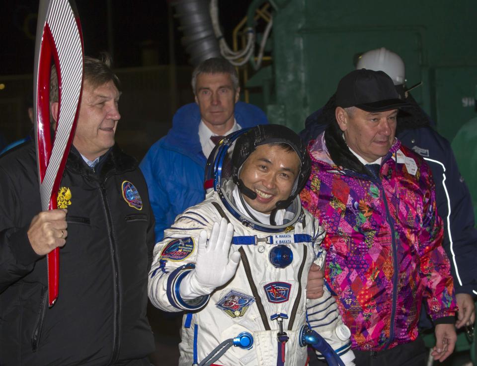 Japanese astronaut Koichi Wakata walks to board the Soyuz TMA-11M spacecraft at the Baikonur cosmodrome