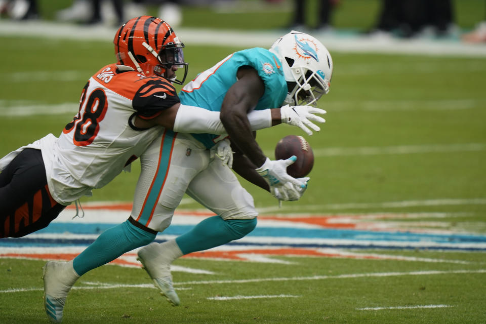 Cincinnati Bengals cornerback LeShaun Sims (38) defends Miami Dolphins wide receiver Jakeem Grant (19) as Grant is unable to hold onto the football, during the first half of an NFL football game, Sunday, Dec. 6, 2020, in Miami Gardens, Fla. (AP Photo/Wilfredo Lee)