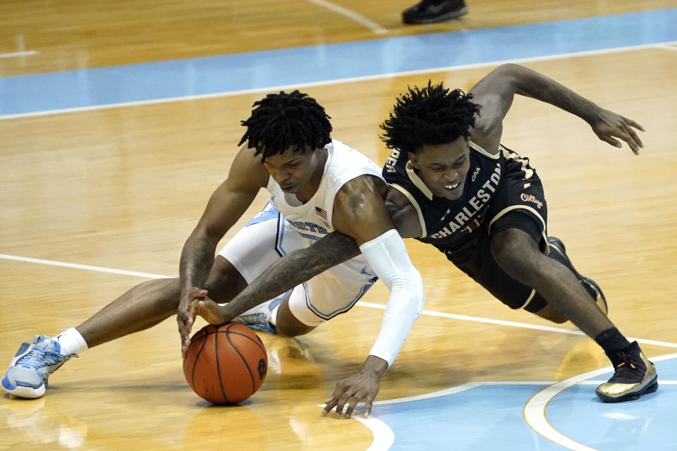 North Carolina guard Caleb Love, left, and College of Charleston guard Zep Jasper chase a loose ball during the first half of an NCAA basketball game in Chapel Hill, N.C., Wednesday, Nov. 25, 2020. (AP Photo/Gerry Broome)