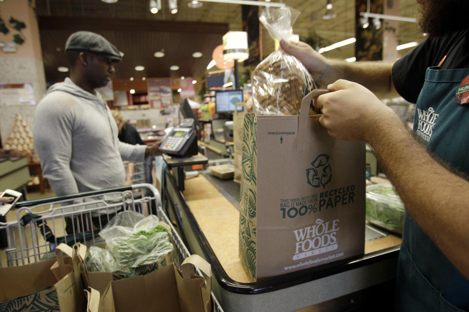 FILE - In this Nov. 3, 2010 photo, a worker bags a customer's items at Whole Foods, in Coral Gables, Fla. Whole Foods Market Inc. releases quarterly financial earnings Wednesday, Feb. 9, 2011, after the market close.(AP Photo/Lynne Sladky, file)