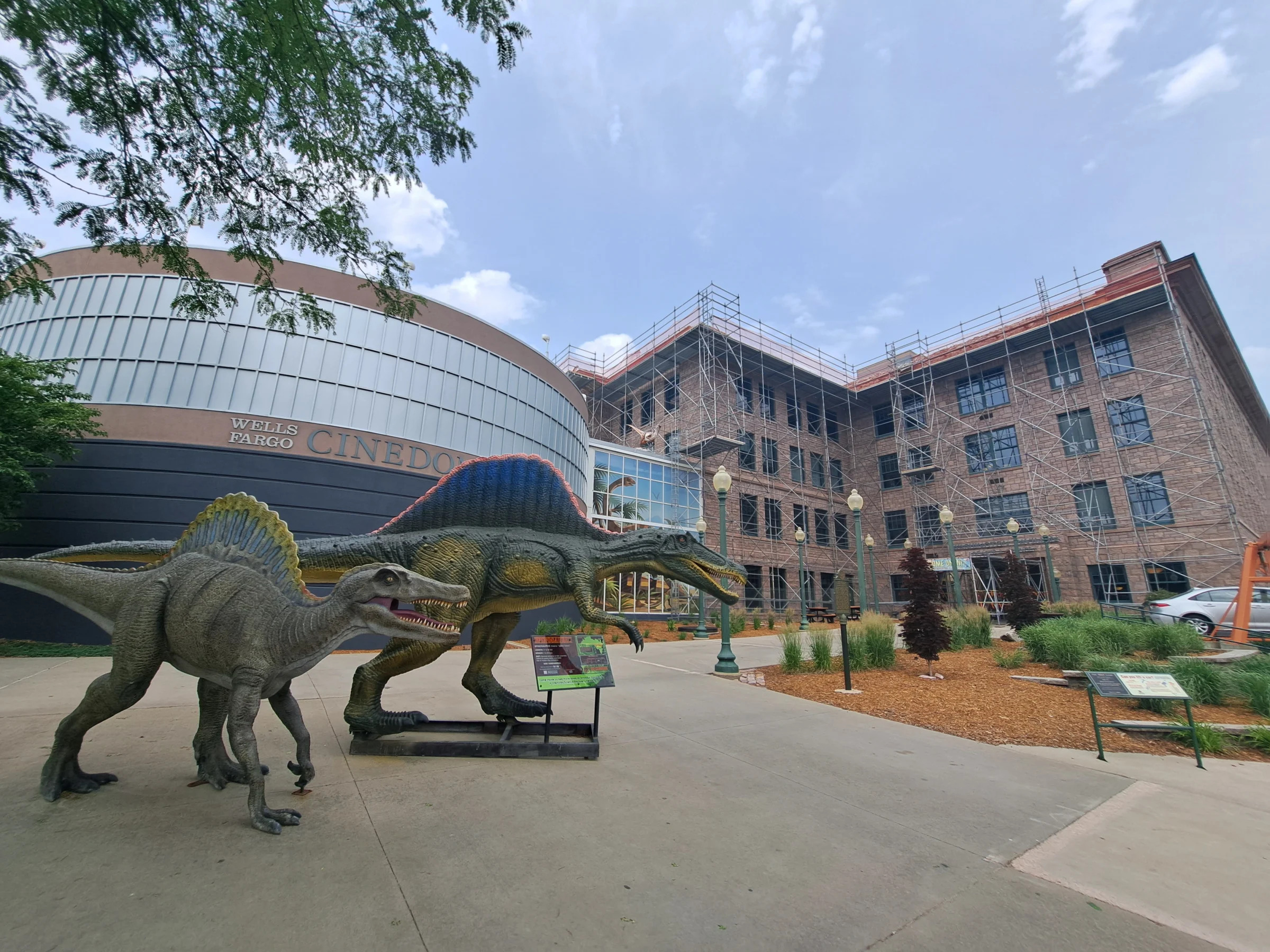 Two spinosaurus statues decorate the west side of the Washington Pavilion on Friday, June 16, 2023, in downtown Sioux Falls. The two are part of a several dinosaur statues featured outside of the pavilion, often used for pictures by the public. In the background, above the two, is a smaller velociraptor perched on the roof of the building, one of two velociraptors featured outside. The other, not pictured, was stolen Thursday, June 15, 2023, Sioux Falls Police Department officials said.