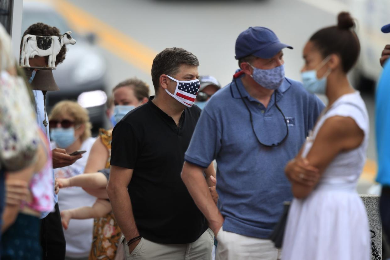 Customers wear pandemic masks while waiting to place an order at a food stand on Wednesday, July 22, 2020, in Wiscasset, Maine. On Thursday, the Maine Center for Disease Control reported a net increase of 14 coronavirus cases in the state.