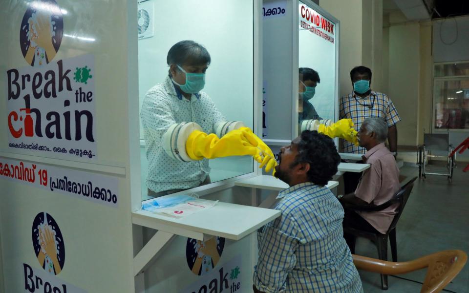 Medical staff members of a government-run medical college collect swabs from people to test for coronavirus disease (COVID-19) at a newly installed Walk-In Sample Kiosk (WISK) in Ernakulam in the southern state of Kerala, India - Reuters