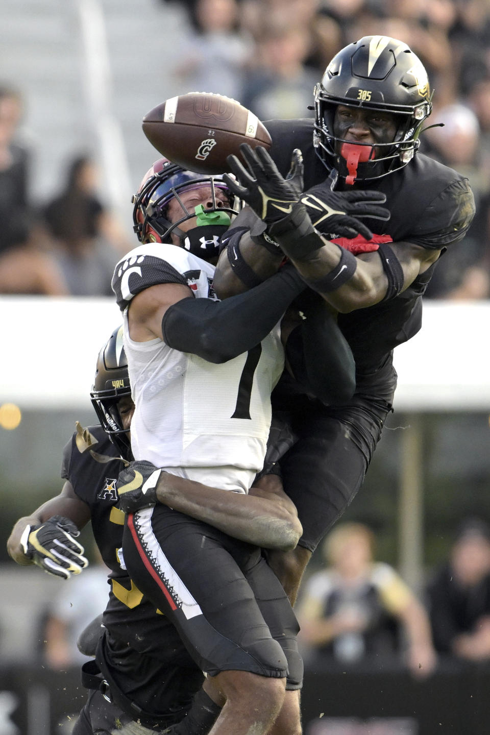 Central Florida cornerback Brandon Adams, left, and defensive back Divaad Wilson, right, break up a pass intended for Cincinnati wide receiver Tre Tucker (1) during the second half of an NCAA college football game, Saturday, Oct. 29, 2022, in Orlando, Fla. (AP Photo/Phelan M. Ebenhack)