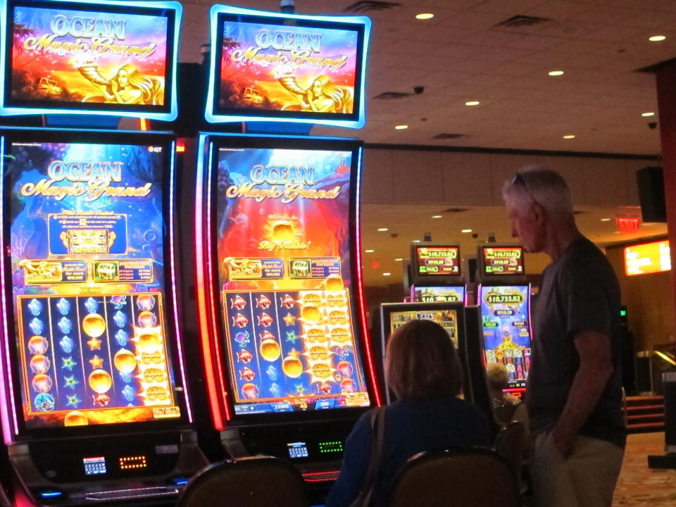 This June 23, 2021 photo shows people playing slot machines at Bally's casino in Atlantic City N.J. On Oct. 25, 2021, panelists at the East Coast Gaming Congress in Atlantic City pondered what the casino floor of the future should look like, including how to attract the next generation of gamblers. (AP Photo/Wayne Parry)