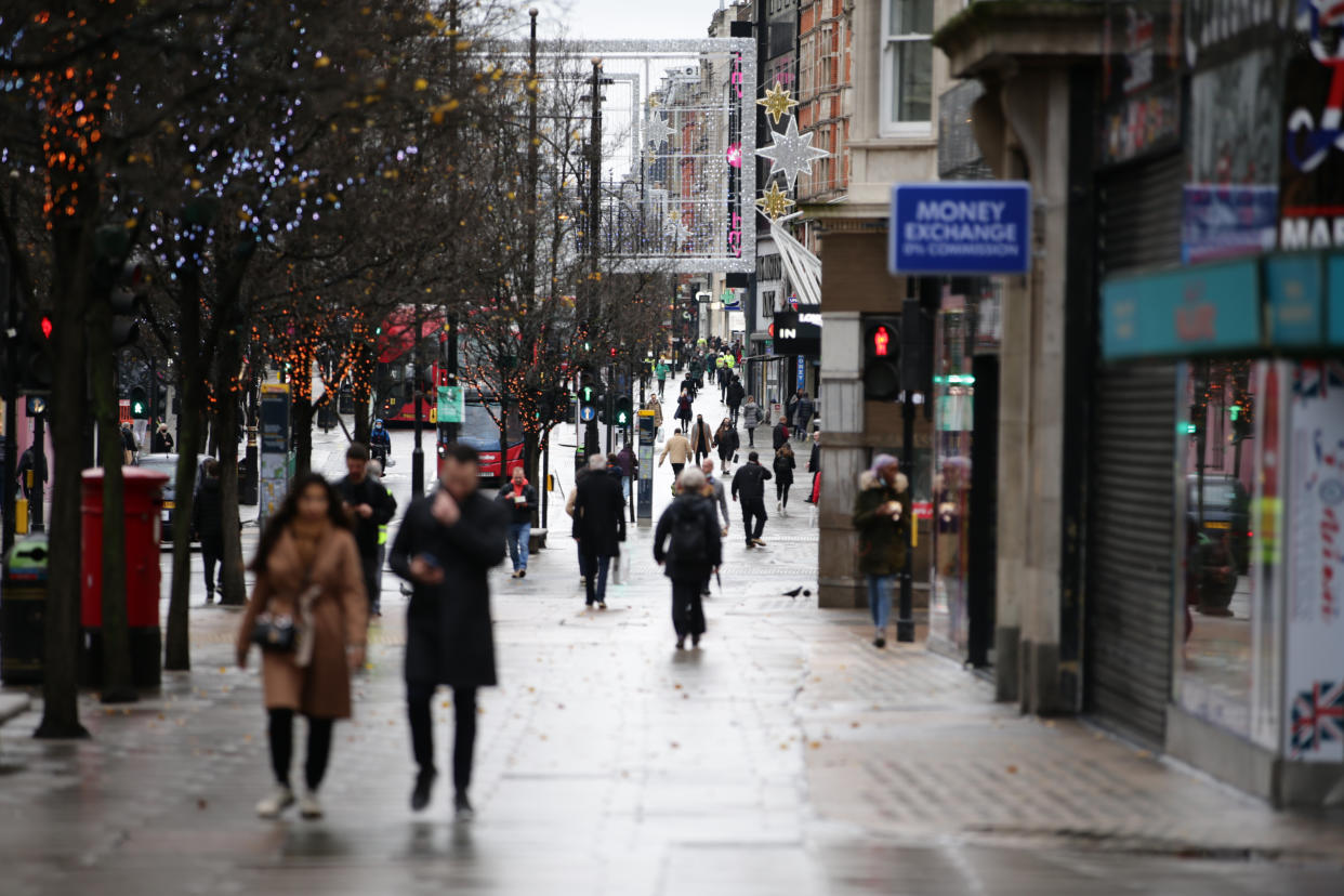 People walk past temporarily-closed stores on Oxford Street in London, England, on December 21, 2020. London spent its second day of what could be months under newly-introduced 'Tier 4' coronavirus restrictions today. Under Tier 4 rules non-essential shops and many other businesses including gyms and hairdressers must close, with people instructed to stay at home other than for exempted circumstances including travel to work or education. Indoor mixing between those in different households is also banned under the new tier, upending Christmas plans for a huge swathe of the population. Concern over a more infectious strain of the coronavirus in the UK has meanwhile seen dozens of countries ban arrivals from Britain, with food supplies also disrupted after France closed the cross-Channel freight route from Dover. (Photo by David Cliff/NurPhoto via Getty Images)