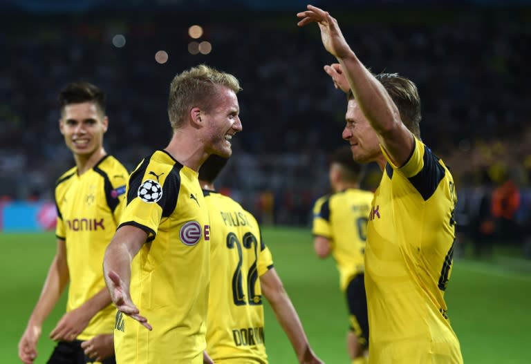 Dortmund's Andre Schuerrle (C) celebrates with teammate Lukasz Piszczek after scoring a goal during their UEFA Champions League first leg match against Real Madrid, at BVB stadium in Dortmund, on September 27, 2016