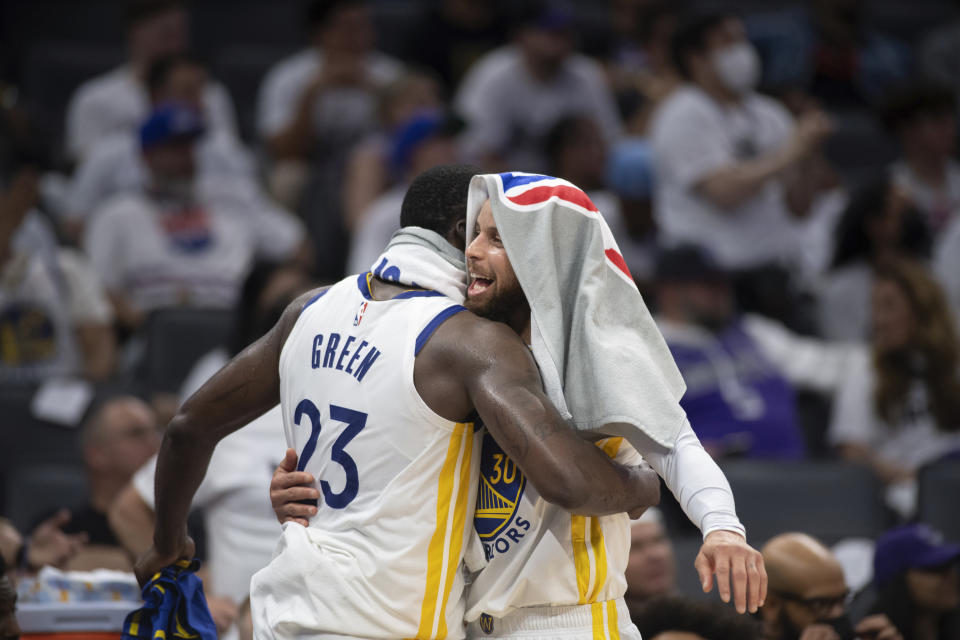 Golden State Warriors guard Stephen Curry (30) embraces teammate Draymond Green (23) after they were removed during the second half of Game 7 of an NBA basketball first-round playoff series against the Sacramento Kings,Sunday, April 30, 2023, in Sacramento, Calif. (AP Photo/José Luis Villegas)