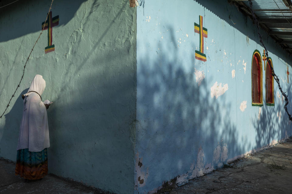 A Tigrayan woman who fled the conflict in Ethiopia's Tigray region, prays during Sunday Mass at a church, near Umm Rakouba refugee camp in Qadarif, eastern Sudan, Nov. 29, 2020. (AP Photo/Nariman El-Mofty)