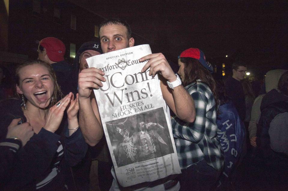 A student displays the front page of the Hartford Courant after the Connecticut Huskies defeated the Kentucky Wildcats in the men's final NCAA Final Four college basketball championship game at the University of Connecticut in Storrs, Connecticut April 7, 2014. Connecticut's experience trumped Kentucky's youth as the Huskies prevailed with a 60-54 NCAA national championship victory on Monday that completed a turnaround for the recently penalized program. Picture taken April 7, 2014. REUTERS/Michelle McLoughlin (UNITED STATES - Tags: SPORT BASKETBALL MEDIA)