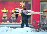 A man carries a mannequin in the Belarus capital Minsk, on December 10, 2012. AFP PHOTO / VIKTOR DRACHEV