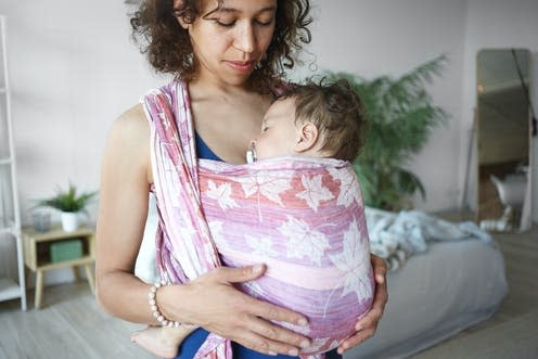 <span class="caption">Keeping your baby close – such as in a sling – will soothe them and improve your bond.</span> <span class="attribution"><a class="link " href="https://www.shutterstock.com/image-photo/indoor-portrait-young-20-year-old-1197702385" rel="nofollow noopener" target="_blank" data-ylk="slk:shurkin_son/ Shutterstock;elm:context_link;itc:0;sec:content-canvas">shurkin_son/ Shutterstock</a></span>