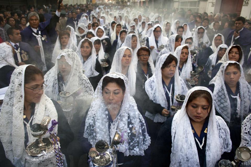 Women burn incense while participating in a Good Friday procession honoring "The Lord of Miracles", the patron saint of Lima, Peru, on Friday, April 18, 2014. Christians all over the world are marking Good Friday, the day when Jesus Christ was crucified. (AP Photo/Rodrigo Abd)