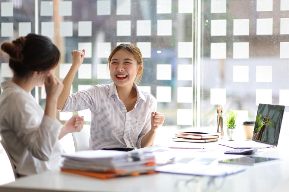 Businesswoman and office colleagues express excitement and happiness as the job is accomplished and the bonus is awarded.