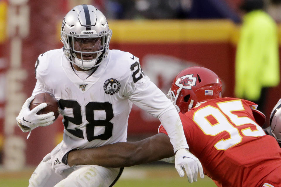 Oakland Raiders running back Josh Jacobs (28) tries to break a tackle by Kansas City Chiefs defensive tackle Chris Jones (95) during the first half of an NFL football game in Kansas City, Mo., Sunday, Dec. 1, 2019. (AP Photo/Charlie Riedel)