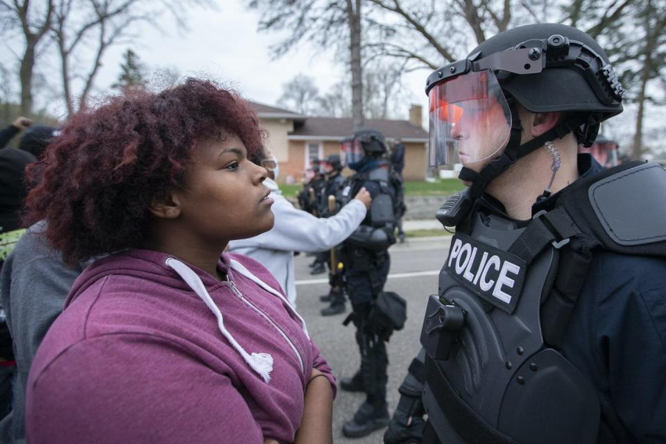 A protester stares down a police officer during a protest in Brooklyn Center, Minnesota.