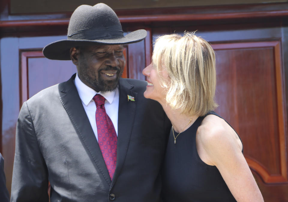 South Sudan's President Salva Kiir, left, and U.S. Ambassador to the U.N. Kelly Craft react as they talk, Sunday, Oct.20, 2019, while posing for pictures with the rest of the U.N. Security Council during the group's one-day visit to the capital Juba on Sunday to discuss the country's peace deal. Machar made an impassioned plea to a visiting United Nations Security Council delegation that met with him and President Salva Kiir to urge speedier progress in pulling the country out of a five-year civil war.(AP Photo/Sam Mednick)